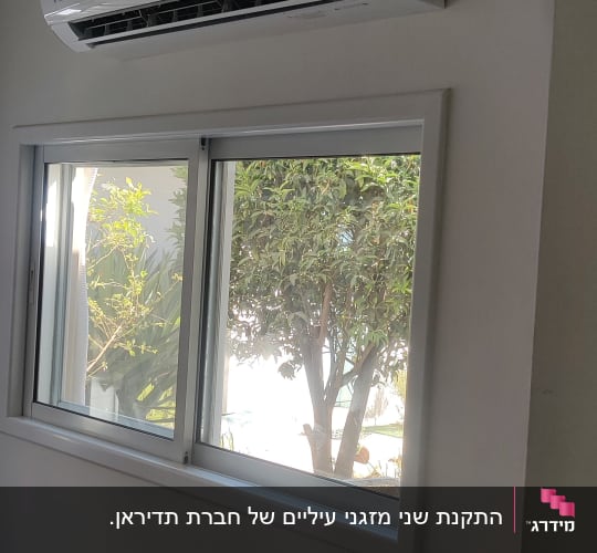 מזגן מותקן על קיר מעל חלון